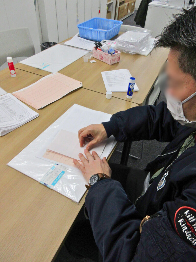 写真。男性が貼り付け作業をしている。