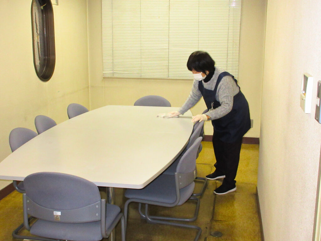 写真。会議室の清掃を行なっている。